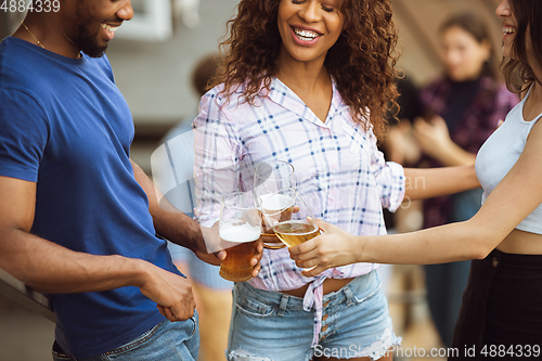 Image of Group of happy friends having beer party in summer day. Resting together outdoor, celebrating and relaxing, laughting. Summer lifestyle, friendship concept.