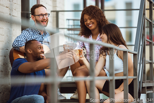 Image of Group of happy friends having beer party in summer day. Resting together outdoor, celebrating and relaxing, laughting. Summer lifestyle, friendship concept.