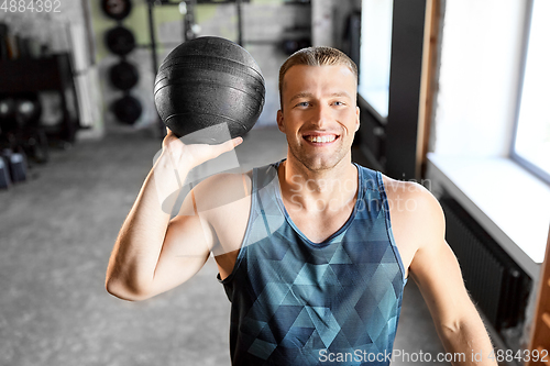 Image of happy smiling young man with medicine ball in gym