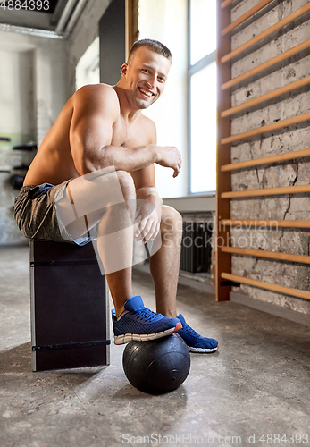 Image of happy smiling young man with medicine ball in gym