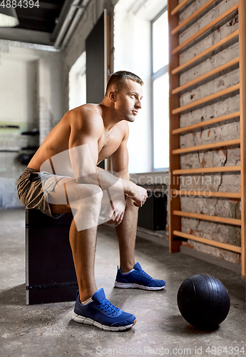 Image of young man with medicine ball in gym