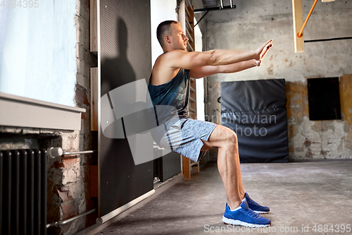 Image of young man exercising with medicine ball in gym