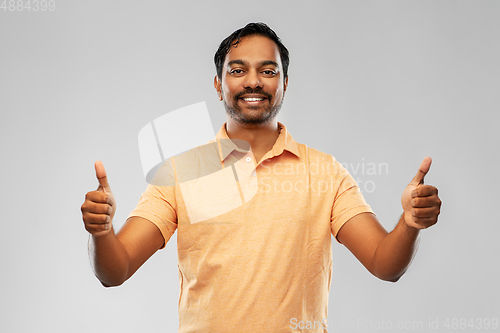 Image of portrait of happy indian man showing thumbs up