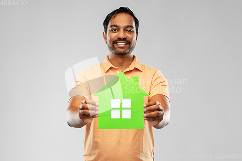 Image of smiling indian man holding green house icon