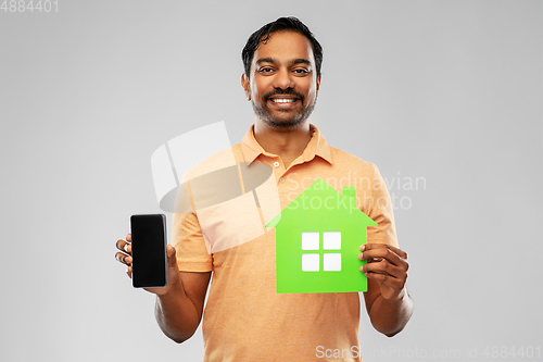 Image of happy indian man with green house and smartphone