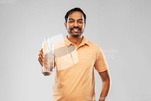 Image of happy indian man showing water in glass bottle