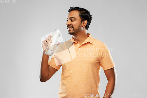 Image of happy indian man drinking water from glass bottle