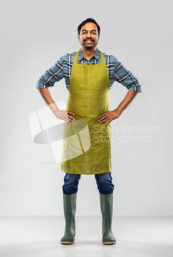 Image of happy indian male gardener or farmer in apron