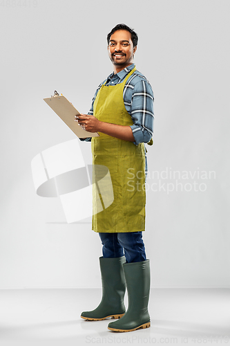 Image of happy indian gardener or farmer with clipboard
