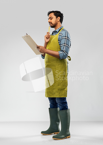 Image of indian gardener or farmer with clipboard thinking