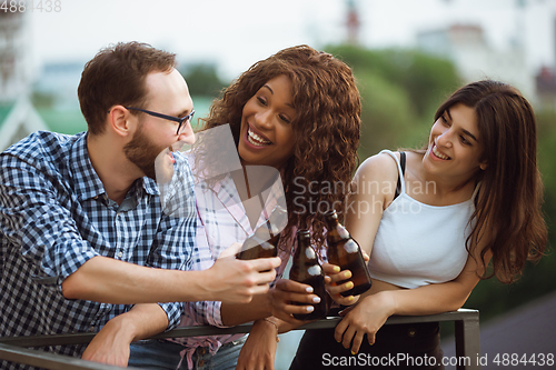 Image of Group of happy friends having beer party in summer day. Resting together outdoor, celebrating and relaxing, laughting. Summer lifestyle, friendship concept.