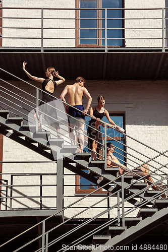 Image of The group of modern ballet dancers performing on the stairs at the city