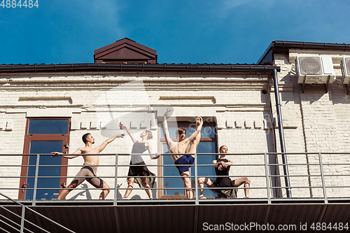 Image of The group of modern ballet dancers performing on the stairs at the city