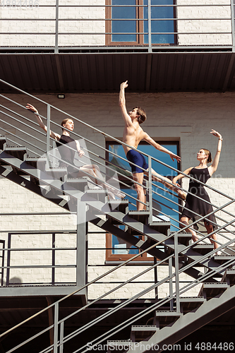 Image of The group of modern ballet dancers performing on the stairs at the city