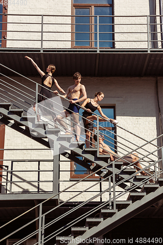 Image of The group of modern ballet dancers performing on the stairs at the city