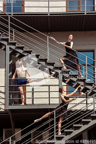 Image of The group of modern ballet dancers performing on the stairs at the city