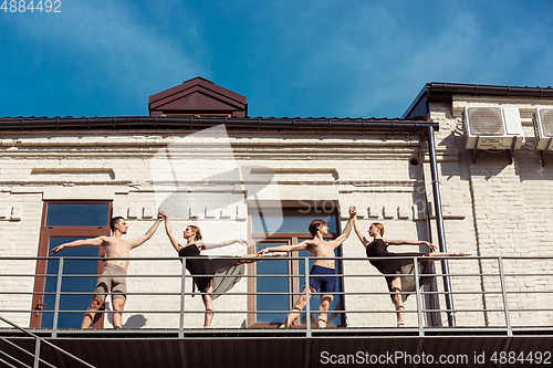 Image of The group of modern ballet dancers performing on the stairs at the city