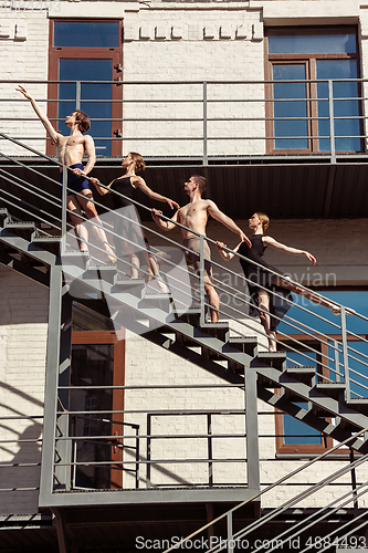 Image of The group of modern ballet dancers performing on the stairs at the city