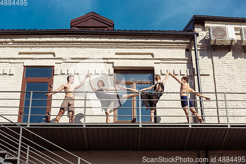 Image of The group of modern ballet dancers performing on the stairs at the city