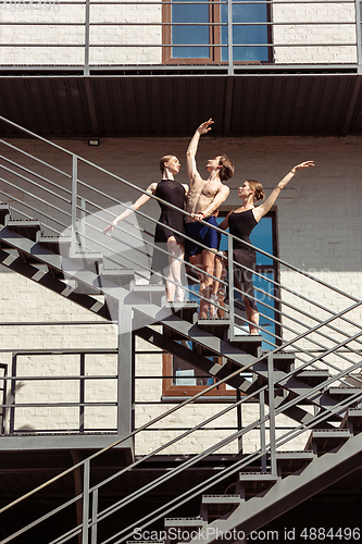 Image of The group of modern ballet dancers performing on the stairs at the city