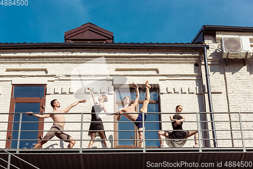 Image of The group of modern ballet dancers performing on the stairs at the city