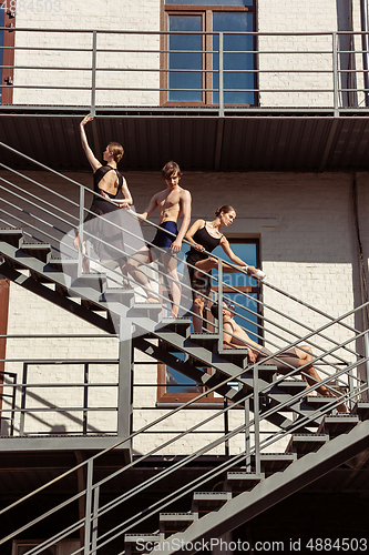 Image of The group of modern ballet dancers performing on the stairs at the city