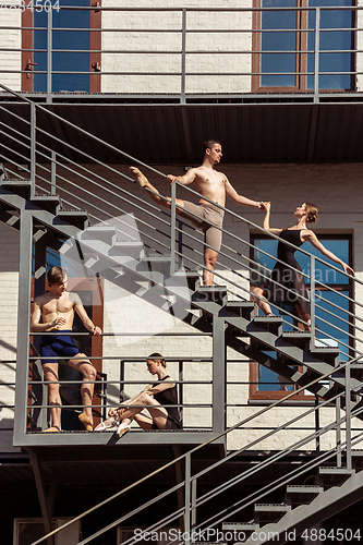 Image of The group of modern ballet dancers performing on the stairs at the city