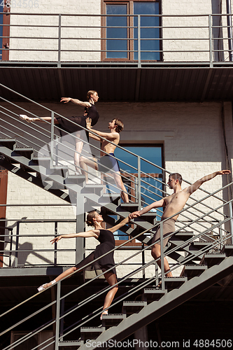 Image of The group of modern ballet dancers performing on the stairs at the city