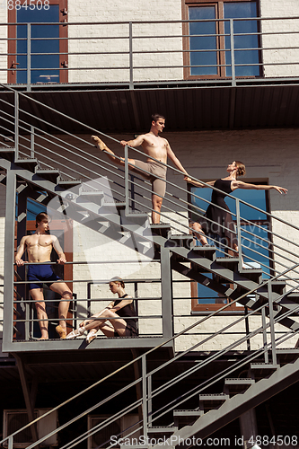 Image of The group of modern ballet dancers performing on the stairs at the city