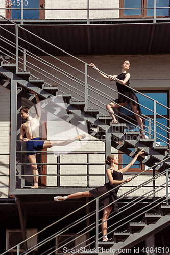 Image of The group of modern ballet dancers performing on the stairs at the city