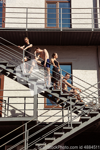 Image of The group of modern ballet dancers performing on the stairs at the city