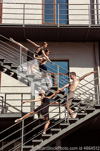 Image of The group of modern ballet dancers performing on the stairs at the city