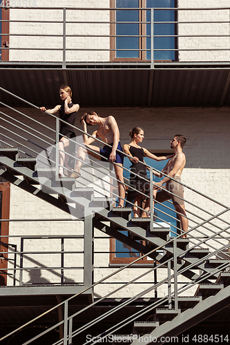 Image of The group of modern ballet dancers performing on the stairs at the city