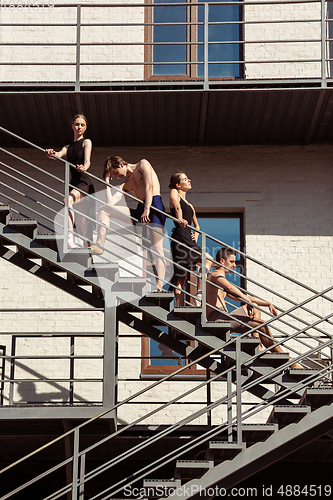 Image of The group of modern ballet dancers performing on the stairs at the city