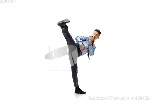 Image of Man in office clothes practicing taekwondo on white background. Unusual look for businessman in motion, action. Sport, healthy lifestyle.