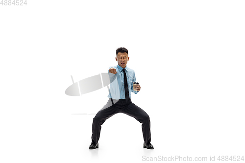 Image of Man in office clothes practicing taekwondo on white background. Unusual look for businessman in motion, action. Sport, healthy lifestyle.