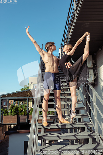 Image of Couple of modern ballet dancers performing on the stairs at the city