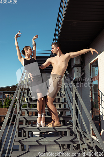 Image of Couple of modern ballet dancers performing on the stairs at the city