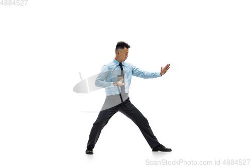 Image of Man in office clothes practicing taekwondo on white background. Unusual look for businessman in motion, action. Sport, healthy lifestyle.