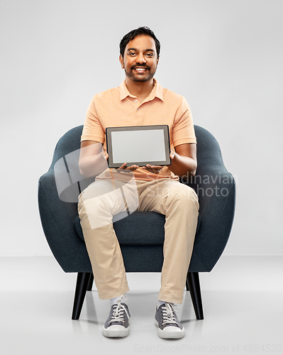 Image of happy indian man with tablet pc computer in chair