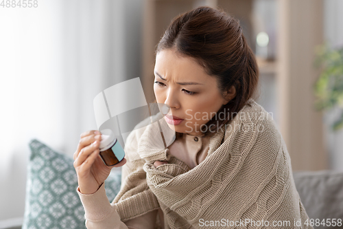 Image of sick asian woman with medicine at home