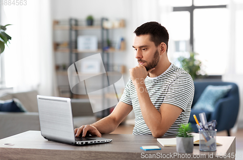 Image of man with laptop working at home office