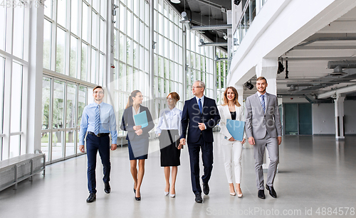 Image of business people walking along office building