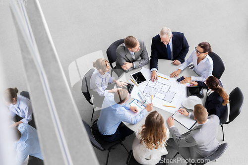 Image of architects with laptop and blueprint at office