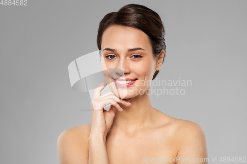 Image of beautiful young woman touching her face