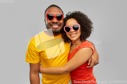 Image of happy african couple in heart shaped suglasses