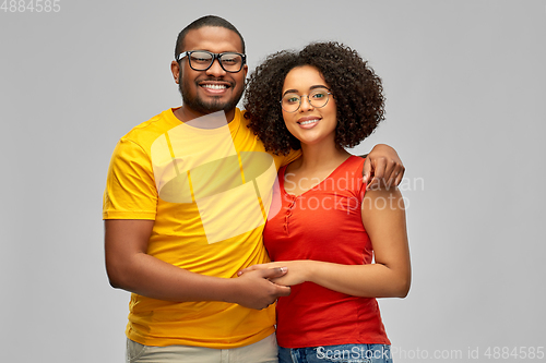 Image of happy african american couple in glasses hugging