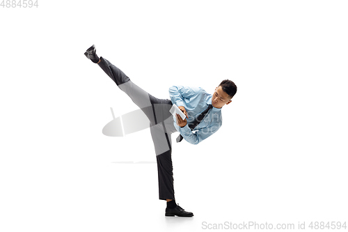 Image of Man in office clothes practicing taekwondo on white background. Unusual look for businessman in motion, action. Sport, healthy lifestyle.