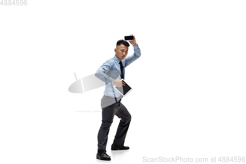 Image of Man in office clothes practicing taekwondo on white background. Unusual look for businessman in motion, action. Sport, healthy lifestyle.