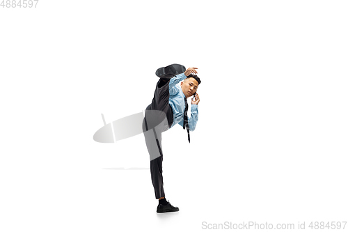 Image of Man in office clothes practicing taekwondo on white background. Unusual look for businessman in motion, action. Sport, healthy lifestyle.
